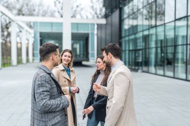 Bir grup genç iş adamı borsa ve değişim uzmanları, modern bilim, finans ve ekonomi liderleri ofis binasının önünde duruyorlar. Personel üyeleri iş adamı ve iş kadınıyla tanışıyor