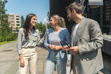 Bir grup genç iş adamı borsa ve değişim uzmanları, modern bilim, finans ve ekonomi liderleri ofis binasının önünde duruyorlar. Personel üyeleri iş adamı ve iş kadınıyla tanışıyor