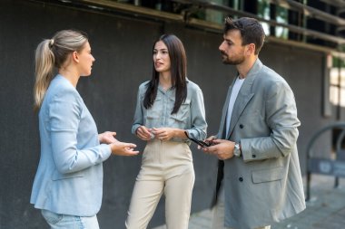 Bir grup modern başarılı iş adamı yenilikçi teknoloji uzmanları ofis binasının dışında duruyor, fikirler ve yenilikler tartışıyorlar. Küresel pazarlama stratejisinin liderleri profesyonel işgal