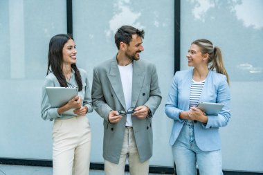 Bir grup modern başarılı iş adamı yenilikçi teknoloji uzmanları ofis binasının dışında duruyor, fikirler ve yenilikler tartışıyorlar. Küresel pazarlama stratejisinin liderleri profesyonel işgal