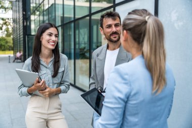 Bir grup modern başarılı iş adamı yenilikçi teknoloji uzmanları ofis binasının dışında duruyor, fikirler ve yenilikler tartışıyorlar. Küresel pazarlama stratejisinin liderleri profesyonel işgal