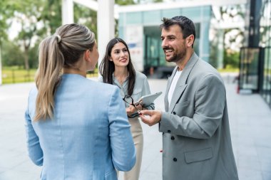 Bir grup modern başarılı iş adamı yenilikçi teknoloji uzmanları ofis binasının dışında duruyor, fikirler ve yenilikler tartışıyorlar. Küresel pazarlama stratejisinin liderleri profesyonel işgal