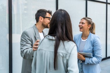Bir grup modern başarılı iş adamı yenilikçi teknoloji uzmanları ofis binasının dışında duruyor, fikirler ve yenilikler tartışıyorlar. Küresel pazarlama stratejisinin liderleri profesyonel işgal
