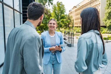Bir grup modern başarılı iş adamı yenilikçi teknoloji uzmanları ofis binasının dışında duruyor, fikirler ve yenilikler tartışıyorlar. Küresel pazarlama stratejisinin liderleri profesyonel işgal