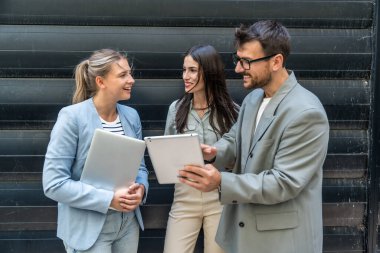 Bir grup modern başarılı iş adamı yenilikçi teknoloji uzmanları ofis binasının dışında duruyor, fikirler ve yenilikler tartışıyorlar. Küresel pazarlama stratejisinin liderleri profesyonel işgal