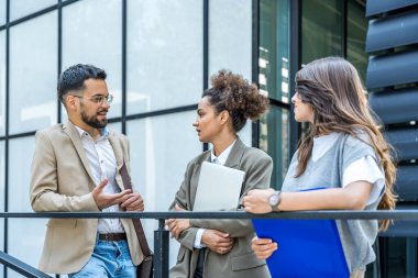 Bir grup modern başarılı iş adamı yenilikçi teknoloji uzmanları ofis binasının dışında duruyor, fikirler ve yenilikler tartışıyorlar. Küresel pazarlama stratejisinin liderleri profesyonel işgal