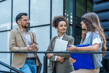 Bir grup modern başarılı iş adamı yenilikçi teknoloji uzmanları ofis binasının dışında duruyor, fikirler ve yenilikler tartışıyorlar. Küresel pazarlama stratejisinin liderleri profesyonel işgal