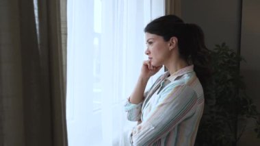 Evdeki üzgün düşünceli kadın. Depresyon mevsimsel duygusal akıl sağlığı bozukluğu pencereden tek başına bakıyor. İnsanlardan kendini soyutlama. Depresyondaki kadın anksiyete yaşıyor.