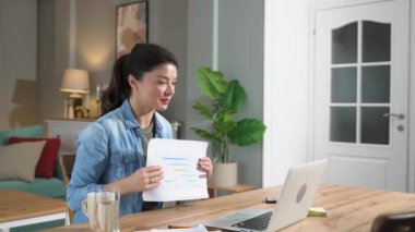 Genç iş kadını serbest yurtdışında çalışan finansal ve dijital pazarlama uzmanı evde çalışıyor ve dizüstü bilgisayarlı web kamerasında video görüşmesi yapıyor. İnternet fırsatları küresel iş