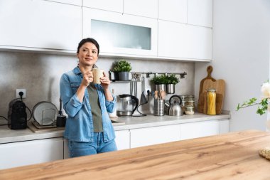 Genç, mutlu, yeni boşanmış, ya da yeni boşanmış, zehirli bir ilişkiden yeni çıkmış, mutfakta durmuş, kahve ya da çay kiralıyor, yeni başlangıçların tadını çıkarıyor ve sabah sessizliğinin tadını çıkarıyor.