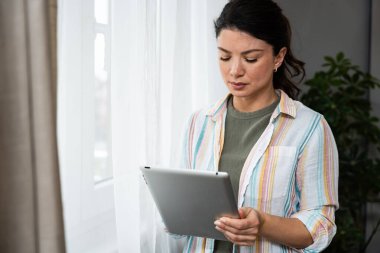 Pencereden bakan tabletli bir emlakçı. Evde çalışan genç bir iş kadını, cihaz kullanıyor. Başarılı profesyonel meslek grafik tasarımcısı kadın işe ara veriyor..