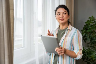 Pencereden bakan tabletli bir emlakçı. Evde çalışan genç bir iş kadını, cihaz kullanıyor. Başarılı profesyonel meslek grafik tasarımcısı kadın işe ara veriyor..