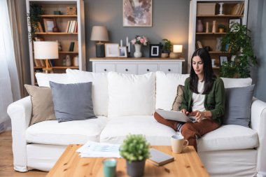 Konsantre olmuş milenyum kızı, evinde dizüstü bilgisayarla internette gezinirken tembelce hafta sonu boyunca bilgisayar sörfü yaparak internetten internet alışverişi yapmakla meşgul.
