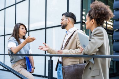 Beyin fırtınası. Bir grup yenilikçi iş adamı, işadamı ve işkadını ofis binasının dışında duruyor, şirket yönetimiyle personel toplantısında sunuma hazırlanıyorlar..