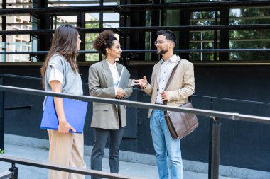 Beyin fırtınası. Bir grup yenilikçi iş adamı, işadamı ve işkadını ofis binasının dışında duruyor, şirket yönetimiyle personel toplantısında sunuma hazırlanıyorlar..