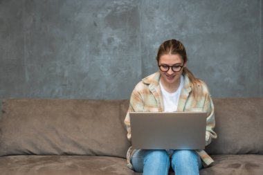Tasarımcı, serbest çalışan genç bir kadın, havalı ev ofis stüdyosunda çalışıyor, modern teknoloji ve küresel iş istatistikleri ve yenilikleri. Pazarlama ve ticaretten sorumlu kadın göçmen..
