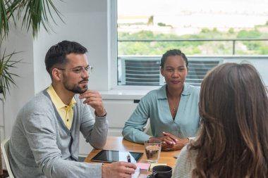 Profesyonel tasarım. Bir grup yaratıcı serbest iş adamı, personel toplantısı ve modern ofiste yeni fikirler geliştiriyorlar. Yeni başlayan projedeki işçilerin tartışılması. Başarılı planlama