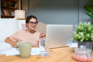 Genç eğitimli bir öğretmen, öğrencilere bilgisayar ve video başında ders veriyor. E-öğrenici, uzaktan eğitimci bayan genç öğrencilere internet eğitimi derslerinde yardım ediyor.