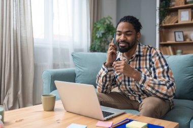 Genç iş adamı, serbest çalışan, gayrimenkul işçisi, müşterilerle online olarak çalışan, apartman teklifleri hakkında konuşan ve tartışan. Başarılı Afrikalı Amerikalı iş adamı konsepti.