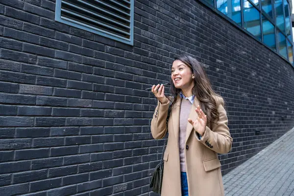 Başarılı bir iş kadını, şirket işinde ofis çalışanı, ofis binasının dışında konuşmak ve iletişim kurmak için akıllı telefonu kullanıyor. Kendini işine adamış bağımsız güçlü CEO kadın çalışma süresinin sonu.