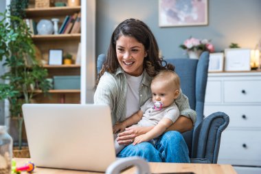 Genç, zeki, yenilikçi bekar anne dizüstü bilgisayarla yeni iş fikrini sunuyor, evde bebekle oturuyor, potansiyel yatırımcıyla konuşuyor. Teknoloji yeniliği.