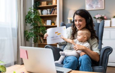 Genç, zeki, yenilikçi bekar anne dizüstü bilgisayarla yeni iş fikrini sunuyor, evde bebekle oturuyor, potansiyel yatırımcıyla konuşuyor. Teknoloji yeniliği.