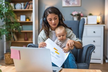 Genç, zeki, yenilikçi bekar anne dizüstü bilgisayarla yeni iş fikrini sunuyor, evde bebekle oturuyor, potansiyel yatırımcıyla konuşuyor. Teknoloji yeniliği.
