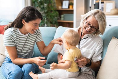 Kadın çocuk doktoru, steteskopla rutin kontrol için küçük çocuğu ziyaret ediyor. Ev ziyareti sağlık ve ilaç, pediatrik kadın sağlık çalışanı.