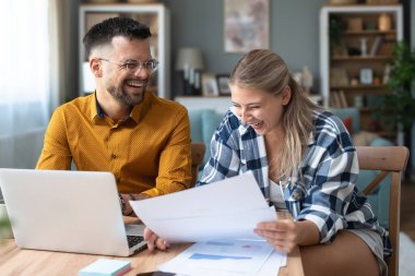 Genç, yenilikçi yenilikçi bir hippi çift yeni iş fikirlerini dizüstü bilgisayarla sunuyorlar, evde çalışıyorlar, potansiyel yatırımcılarla konuşuyorlar. Modern teknoloji yeniliği.