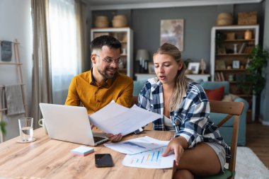 Genç, yenilikçi yenilikçi bir hippi çift yeni iş fikirlerini dizüstü bilgisayarla sunuyorlar, evde çalışıyorlar, potansiyel yatırımcılarla konuşuyorlar. Modern teknoloji yeniliği.