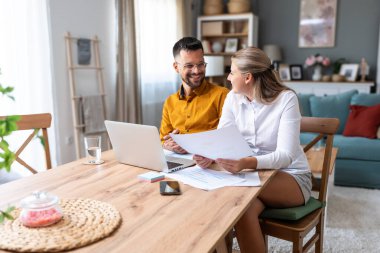 Genç, yenilikçi yenilikçi bir hippi çift yeni iş fikirlerini dizüstü bilgisayarla sunuyorlar, evde çalışıyorlar, potansiyel yatırımcılarla konuşuyorlar. Modern teknoloji yeniliği.