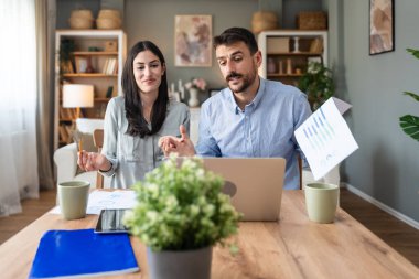 Genç, yenilikçi yenilikçi bir hippi çift yeni iş fikirlerini dizüstü bilgisayarla sunuyorlar, evde çalışıyorlar, potansiyel yatırımcılarla konuşuyorlar. Modern teknoloji yeniliği.