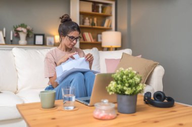 Genç kadın serbest çalışan küçük bir şirket sahibi dizüstü bilgisayarında verilerle vergi iadesi hesaplıyor. İç işlerinde çalışmak, profesyonel meslekte kadın modern teknoloji kullanıcısı..