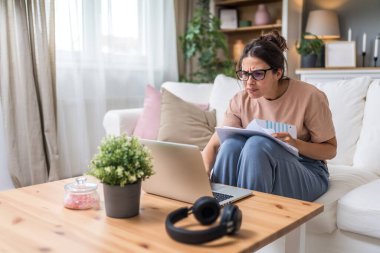 Genç kadın serbest çalışan küçük bir şirket sahibi dizüstü bilgisayarında verilerle vergi iadesi hesaplıyor. İç işlerinde çalışmak, profesyonel meslekte kadın modern teknoloji kullanıcısı..