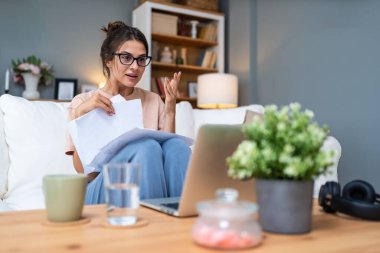 Genç kadın serbest çalışan küçük bir şirket sahibi dizüstü bilgisayarında verilerle vergi iadesi hesaplıyor. İç işlerinde çalışmak, profesyonel meslekte kadın modern teknoloji kullanıcısı..