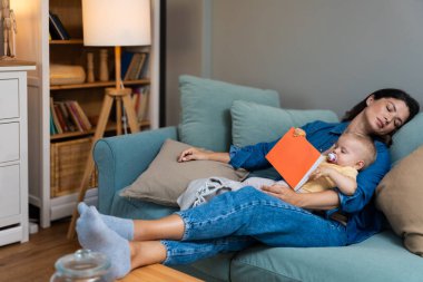 Yorgun anne, kucağında dinlenen küçük kızına masal okurken uykuya dalıyor. Oturma odasındaki kanepede sıcak, sevgi ve akşam sükunetiyle huzurlu bir şekilde dinleniyor.