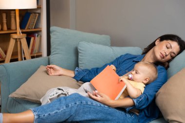 Yorgun anne, kucağında dinlenen küçük kızına masal okurken uykuya dalıyor. Oturma odasındaki kanepede sıcak, sevgi ve akşam sükunetiyle huzurlu bir şekilde dinleniyor.
