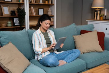 Evdeki Konforlu Oturma Odasında Dijital Tablet Odaklanan Genç Kadın. Serbest İşçi Kadın, Profesyonel İç mimar, Yeni Müşteri İçin Düşünme ve Kullanım İnternet.