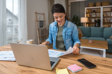 Genç kadın serbest çalışan küçük bir şirket sahibi dizüstü bilgisayarında verilerle vergi iadesi hesaplıyor. İç işlerinde çalışmak, profesyonel meslekte kadın modern teknoloji kullanıcısı..