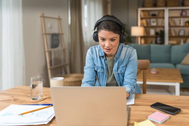 Genç kadın serbest çalışan küçük bir şirket sahibi dizüstü bilgisayarında verilerle vergi iadesi hesaplıyor. İç işlerinde çalışmak, profesyonel meslekte kadın modern teknoloji kullanıcısı..