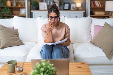 Genç kadın serbest çalışan küçük bir şirket sahibi dizüstü bilgisayarında verilerle vergi iadesi hesaplıyor. İç işlerinde çalışmak, profesyonel meslekte kadın modern teknoloji kullanıcısı..