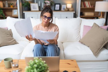 Genç kadın serbest çalışan küçük bir şirket sahibi dizüstü bilgisayarında verilerle vergi iadesi hesaplıyor. İç işlerinde çalışmak, profesyonel meslekte kadın modern teknoloji kullanıcısı..