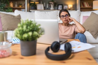 Genç kadın serbest çalışan küçük bir şirket sahibi dizüstü bilgisayarında verilerle vergi iadesi hesaplıyor. İç işlerinde çalışmak, profesyonel meslekte kadın modern teknoloji kullanıcısı..