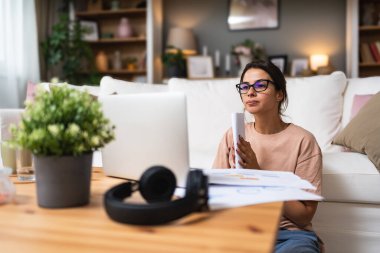 Genç kadın serbest çalışan küçük bir şirket sahibi dizüstü bilgisayarında verilerle vergi iadesi hesaplıyor. İç işlerinde çalışmak, profesyonel meslekte kadın modern teknoloji kullanıcısı..