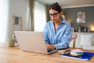 Genç kadın serbest çalışan küçük bir şirket sahibi dizüstü bilgisayarında verilerle vergi iadesi hesaplıyor. İç işlerinde çalışmak, profesyonel meslekte kadın modern teknoloji kullanıcısı..