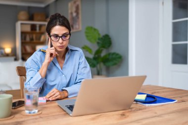 Genç kadın serbest çalışan küçük bir şirket sahibi dizüstü bilgisayarında verilerle vergi iadesi hesaplıyor. İç işlerinde çalışmak, profesyonel meslekte kadın modern teknoloji kullanıcısı..