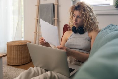 Genç kadın serbest çalışan küçük bir şirket sahibi dizüstü bilgisayarında verilerle vergi iadesi hesaplıyor. İç işlerinde çalışmak, profesyonel meslekte kadın modern teknoloji kullanıcısı.