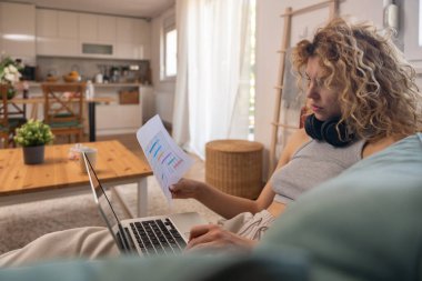 Genç kadın serbest çalışan küçük bir şirket sahibi dizüstü bilgisayarında verilerle vergi iadesi hesaplıyor. İç işlerinde çalışmak, profesyonel meslekte kadın modern teknoloji kullanıcısı.