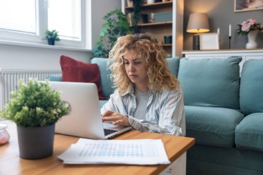 Yerde dizüstü bilgisayar üzerinde çalışırken odaklanma sorunu yaşayan genç bir kadın, basılı analitik, hiperaktivite bozukluğu, zihinsel yorgunluk, tükenmişlik ve modern çoklu görev beklentilerinin baskısı ile mücadele ediyor.