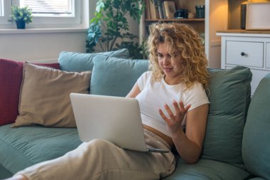 Evde çalışan ve internet bağlantısı kopukluğu, bilgisayar arızası veya sistem hatası gibi teknik sorunlar yaşayan genç bir kadın, evde otururken hayal kırıklığına uğramış ve endişeli